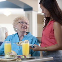 touching hearts at home senior care franchise image of older woman and caretaker